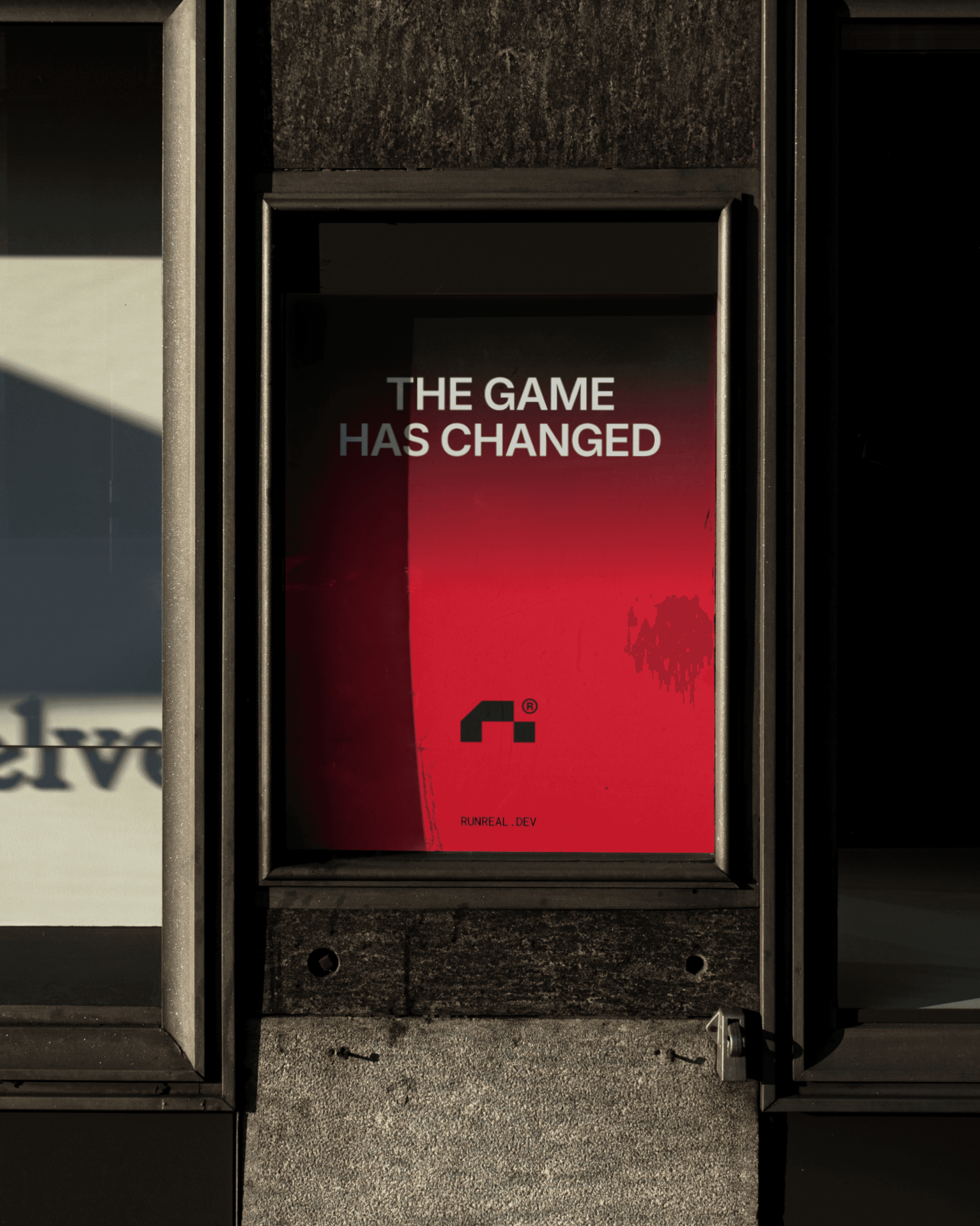Street poster mockup for Runreal with bold red gradient background and the headline “THE GAME HAS CHANGED,” showcasing Kundo Studio’s tech-forward brand identity, typography, and out-of-home launch visuals for the Runreal rebrand.